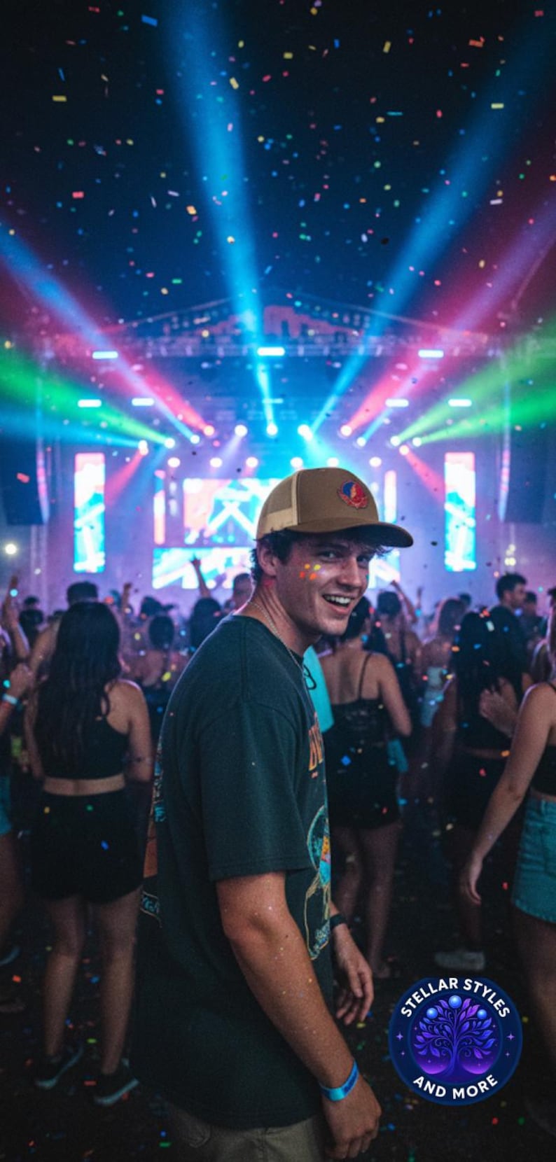 May include: A person wearing a brown and beige trucker hat with a logo, smiling at a concert. The background features a stage with colourful lights and confetti falling. The person is wearing a dark green t-shirt.