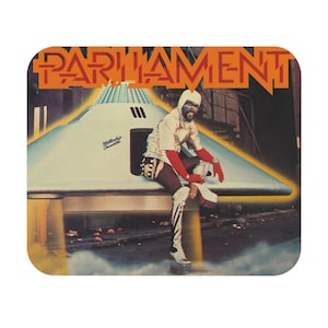 May include: A vintage album cover featuring a person in a white and red outfit sitting on a flying saucer. The saucer is labeled "Mothership Connection". The album cover is titled "Parliament".