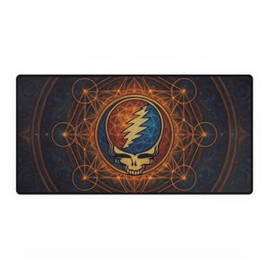 May include: Rectangular desk mat featuring a stylized skull with a lightning bolt, set within a circular design of red, blue, and gold. The background is a dark blue with a geometric pattern. The mat is designed for use with a computer.