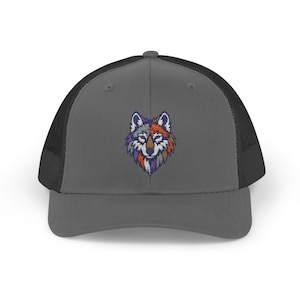 May include: A gray trucker hat with a black mesh back and a colorful embroidered wolf design on the front. The wolf features shades of purple, orange, and gray. The hat has a curved brim and a snapback closure.