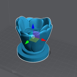 May include: A blue ceramic flower pot with a rounded, petal-like design. The pot has a wide opening and a smaller base.