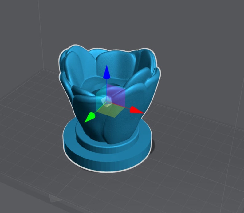 May include: A blue ceramic flower pot with a rounded, petal-like design. The pot has a wide opening and a smaller base.