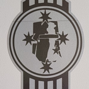 May include: A silver and black logo featuring a stylised image of a person wearing a hat and surrounded by five-pointed stars. The logo is on a silver background with black vertical stripes.