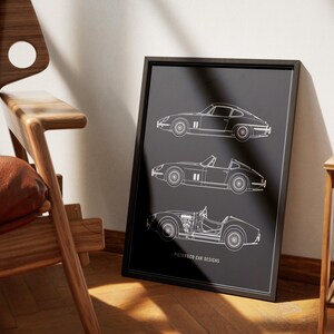 May include: A black framed print with white line drawings of three classic car designs. The text "FICTIONEO CAR DESIGNS" is at the bottom of the print.