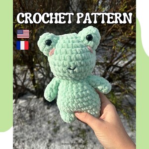 Peut inclure: Patron de crochet pour un jouet amigurumi de grenouille verte. La grenouille a des yeux noirs, des joues roses et une texture au crochet.