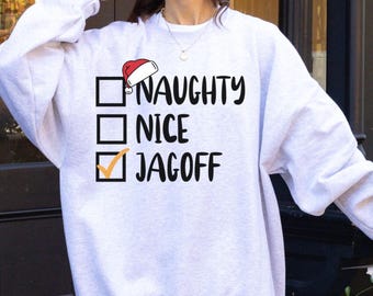 May include: A light gray sweatshirt with the words "NAUGHTY", "NICE", and "JAGOFF" in black text. A Santa hat graphic is above the word "NAUGHTY". The word "JAGOFF" has a checkmark next to it.