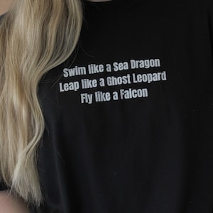 Könnte beinhalten: Schwarzes T-Shirt mit weißem Text, der lautet "Swim like a Sea Dragon Leap like a Ghost Leopard Fly like a Falcon"