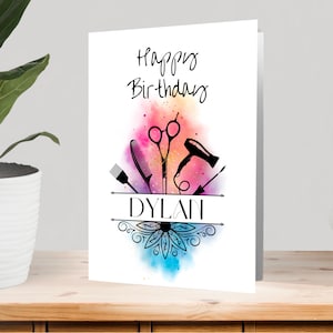 May include: Happy Birthday card with a watercolor background featuring a hair dryer, scissors, combs, and a brush. The name Dylan is written in black text on a white banner.