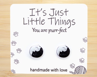 May include: A pair of black and white cat stud earrings on a white card with the text "It's Just Little Things You are purr-fect" and "handmade with love".