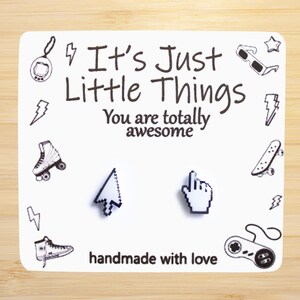 May include: White card with black text that reads "It's Just Little Things You are totally awesome" and "handmade with love". The card features a pair of white pixelated earrings, one shaped like a mouse cursor and the other shaped like a hand pointing with the index finger.
