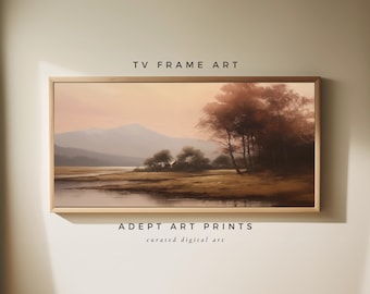 May include: A digital art print of a landscape scene with a lake, mountains, and trees in the foreground. The sky is a soft pink and orange color. The print is framed in a light wood frame. The text "TV FRAME ART" is above the image and the text "ADEPT ART PRINTS curated digital art" is below the image.