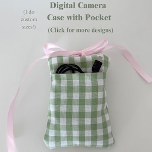 May include: A green and white gingham fabric digital camera case with a front pocket containing a black cable. The case features a light pink ribbon tie closure at the top. Text on the image reads: Digital Camera Case with Pocket (I do custom sizes!) (Click for more designs).