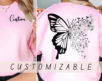 May include: Pink sweatshirt with a black butterfly and floral design on the back. The front of the sweatshirt has the word "Custom" printed on it.