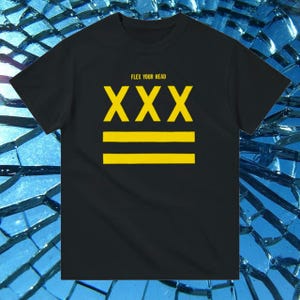 Puede incluir: Camiseta negra con el texto "Flex Your Head" y "XXX" en letras amarillas. Dos líneas horizontales amarillas se encuentran debajo del texto.
