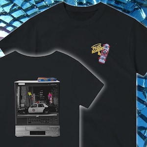 May include: Black t-shirt featuring a graphic of a vintage VCR with a scene from a movie, and a smaller graphic of a skateboard with the text "POLICE ACADEMY 4". The VCR graphic includes a police car and figures.