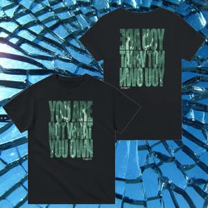 Puede incluir: Dos camisetas negras con texto e imágenes verdes. La primera camiseta dice "You are not what you own." La segunda camiseta dice "Are you talking to me?"