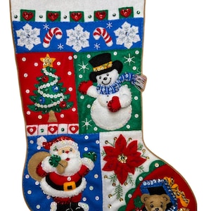 May include: A felt Christmas stocking featuring a white cuff with green sequins, a blue band with snowflakes and candy canes, and panels depicting a decorated Christmas tree, a snowman, Santa Claus, a red poinsettia, and a teddy bear with toys.