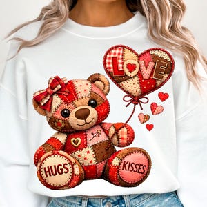 Könnte beinhalten: Weißes Sweatshirt mit einem Patchwork-Teddybär, der einen herzförmigen Ballon mit der Aufschrift "LOVE" hält. Der Bär hat eine rote Schleife und die Pfoten zeigen "HUGS" und "KISSES". Kleine rote Herzen, passend zum Valentinstag.