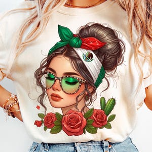 May include: White t-shirt with a colorful illustration of a woman wearing sunglasses and a headband with the Mexican flag. The woman has brown hair and is surrounded by red roses and a cactus.