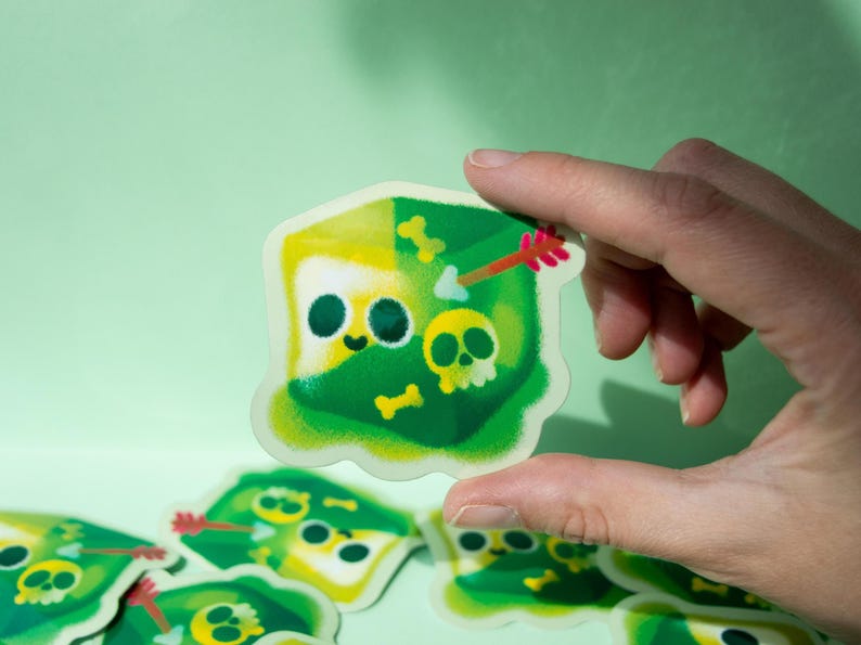 May include: A set of green and yellow stickers featuring a cartoon character with a skull and crossbones design. The character is wearing a green hat and has a happy expression. The stickers are perfect for adding a touch of whimsy to your belongings.