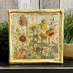 Framed vintage sunflower canvas art with beeswax textured finish, featuring rustic yellow sunflowers and wildflowers in farmhouse style beeswax canvas frame.
