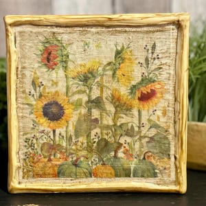 Framed vintage sunflower canvas art with beeswax textured finish, featuring rustic yellow sunflowers and wildflowers in farmhouse style canvas frame.