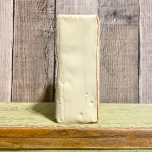 May include: A white ceramic block with a slightly textured surface. The block has a subtle off-white color and is rectangular in shape.