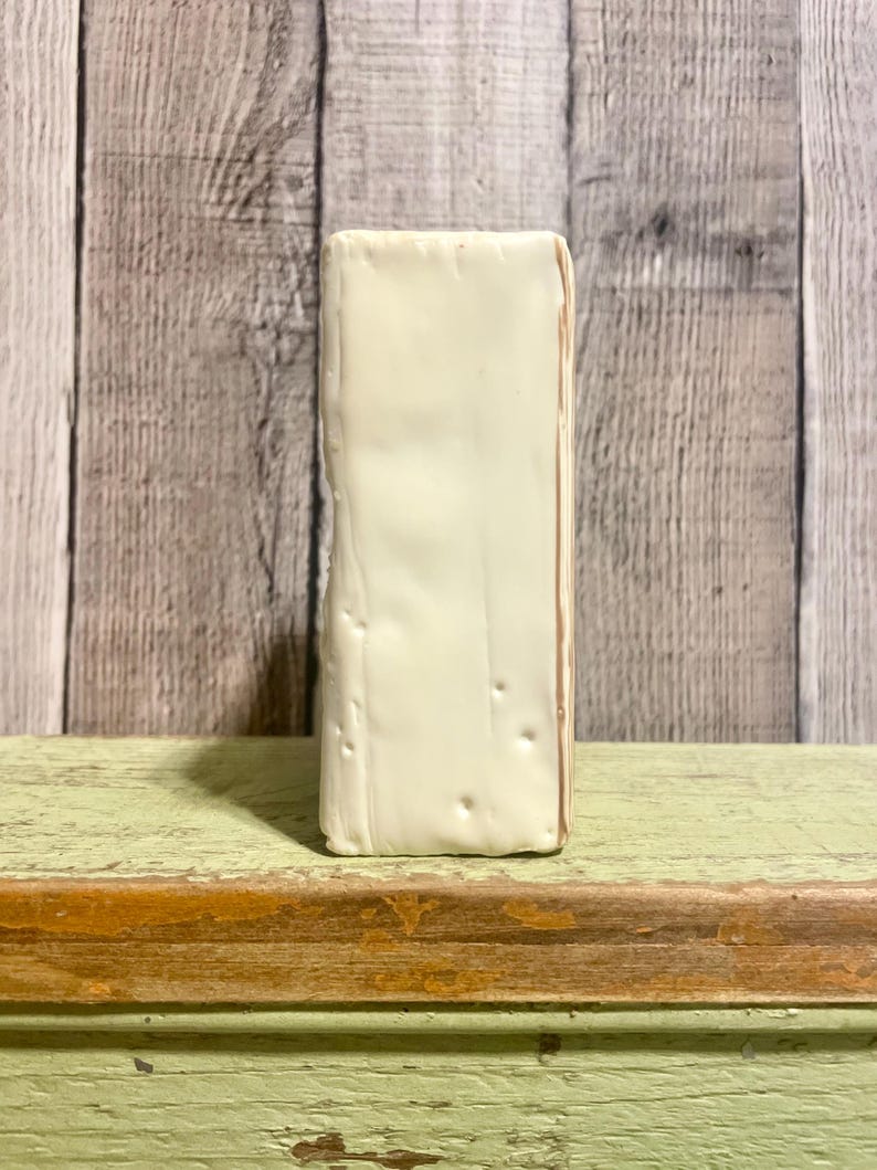 May include: A white ceramic block with a slightly textured surface. The block has a subtle off-white color and is rectangular in shape.