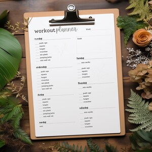 May include: A printable workout planner with a brown clipboard and a white sheet of paper. The paper has a weekly workout schedule with days of the week listed on the left and workout categories listed on the right. The workout categories include: min cardio, push-ups, squats, lunges, and crunches.