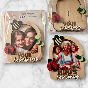 May include: Three wooden photo frames with insect and circle embellishments. Each frame holds a photo and the words "YOUR LOVEBUGS" or "MIMI'S lovebug". The frames are packaged in clear plastic.