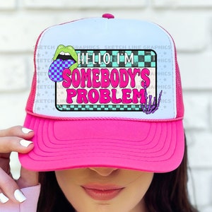 May include: Pink trucker hat with a white mesh back. The hat has a colorful graphic with the text "Hello I'm Somebody's Problem".