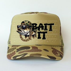 May include: A camouflage trucker hat featuring a cartoon fish wearing sunglasses and a gold chain. The text "BAIT IT" is printed in black on the hat.