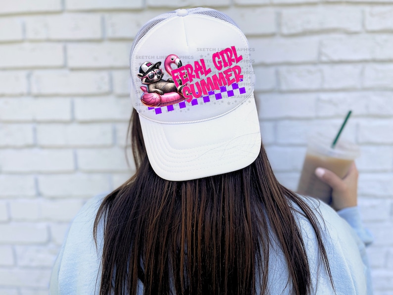 Puede incluir: Gorra de camionero blanca con parte trasera de malla y visera curva. La parte delantera presenta un gr&aacute;fico de un mapache con gafas de sol y sombrero, tumbado en un flotador de flamenco rosa. El texto "FERAL GIRL SUMMER" est&aacute; en rosa y morado.