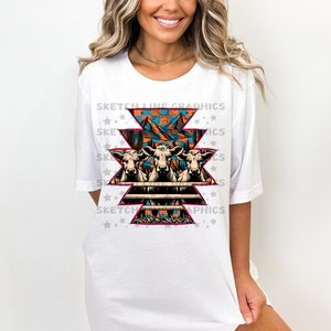 May include: White t-shirt with a graphic design of three cows in front of a fence with a southwestern pattern. The design includes mountains, a sun, and cacti. The text "Sketch Line Graphics" is repeated around the design.