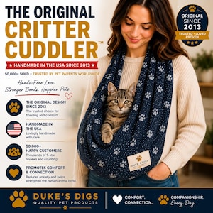 May include: A dark blue pet carrier sling featuring a white paw print pattern and a rectangular Duke's Digs brand label. The text reads The Original Critter Cuddler, Handmade in the USA since 2013, 50,000+ sold, and Hands-Free Love. Stronger Bonds. Happier Pets.