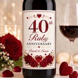 May include: A wine bottle with a cream-colored label featuring the text 40th Ruby ANNIVERSARY and David & Susan. The label is decorated with deep red roses, a sparkling red heart graphic, and smaller red heart accents in a formal design.