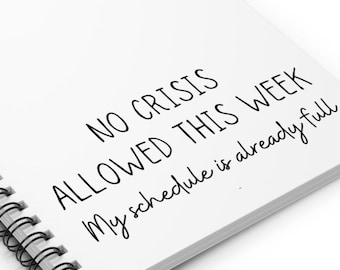 May include: A white spiral notebook with the text "NO CRISIS ALLOWED THIS WEEK My schedule is already full" written in black.