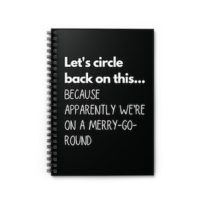 May include: Black spiral notebook with white text that reads "Let's circle back on this... BECAUSE APPARENTLY WE'RE ON A MERRY-GO-ROUND"