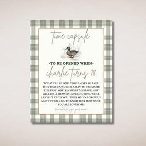 Könnte beinhalten: Eine grün-weiß karierte Karte mit einer Entenillustration und dem Text "Time Capsule - To Be Opened When - Charlie Turns 18". Die Karte enthält Anweisungen zum Erstellen einer Zeitkapsel zum 18. Geburtstag eines Kindes.