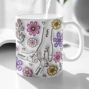 May include: White ceramic mug with a floral design and the words "Mummy", "Joshua", and "Bennett" on it.