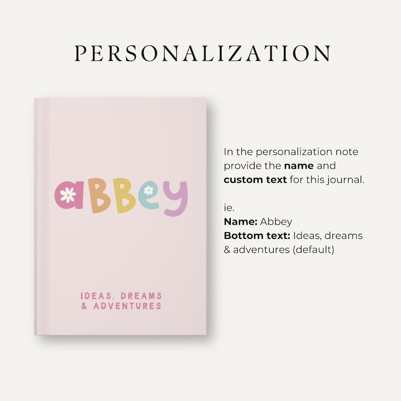 Może przedstawiać: R&oacute;żowa okładka dziennika z imieniem "Abbey" w kolorowych literach z kwiatami. Tekst "IDEAS, DREAMS & ADVENTURES" znajduje się na dole okładki.