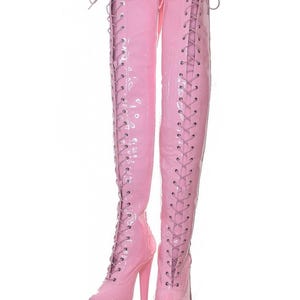 May include: A pair of pink thigh-high boots with lace-up fronts and high heels.