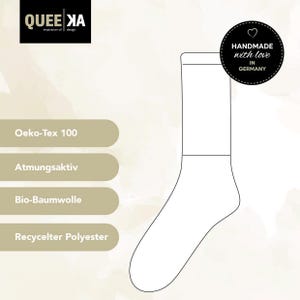Op de afbeelding: Een witte omtrek van een sok met de tekst "HANDMADE with love IN GERMANY" en een hartje. De sok is gelabeld met de volgende kenmerken: "Oeko-Tex 100", "Atmungsaktiv", "Bio-Baumwolle" en "Recycelter Polyester".