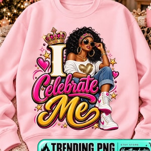 Può includere: Una felpa rosa chiaro con la grafica di una persona dai capelli ricci scuri che indossa occhiali da sole, una corona e un top bianco con un cuore dorato. Il testo I Celebrate Me è scritto in grandi lettere rosa e oro con stelle e cuori.