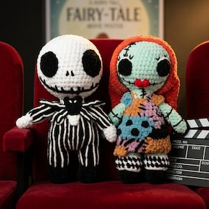 May include: Two handmade crochet plush dolls. The left doll has a white round head with black eye sockets and a stitched mouth, wearing a black and white pinstriped suit. The right doll has light green skin, red hair, and a patchwork dress.