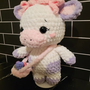 Close-up of customizable crochet cow design from a PDF pattern, emphasizing the adorable head shape, ears, and optional floral accessories.
