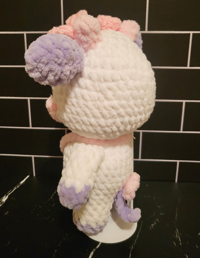 Back view of the completed amigurumi pattern project, showing the seamless color changes and attachment points for the removable satchel bag.