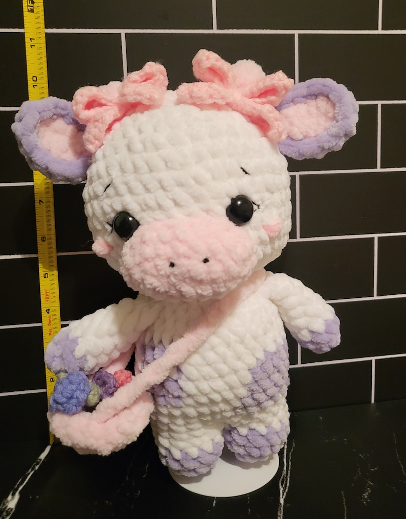 Profile of the crocheted cow, demonstrating the final shape and size (approx. 10 inches) for buyers interested in the amigurumi stuffed animal pattern.