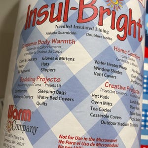 May include: A roll of Insul-Bright needled insulated lining for home projects. The label features a blue and white checkered pattern and lists various project ideas like comforters, oven mitts, and hot pads. The text warns against microwave use.