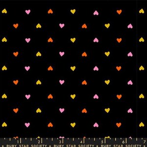 May include: Black fabric with a repeating pattern of small hearts in yellow, pink, and orange. The hearts are evenly spaced across the surface. The text "RUBY STAR SOCIETY" is at the bottom.
